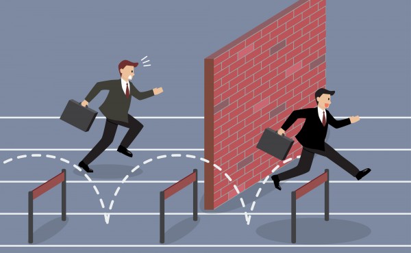 Businessman jumping over hurdle competition