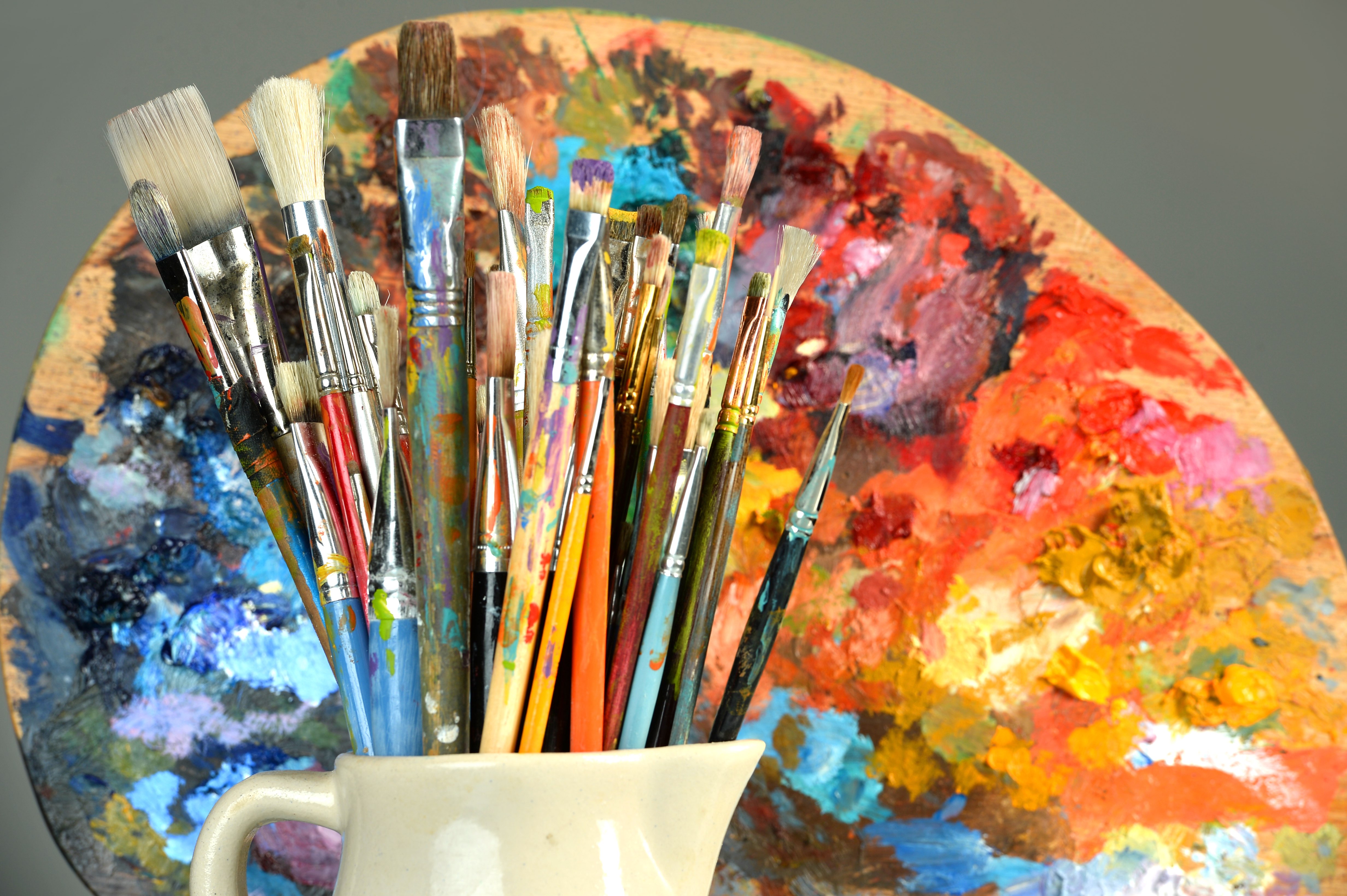 Paintbrushes and palette over gray background