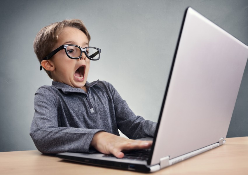 Shocked and surprised boy on the internet with laptop computer