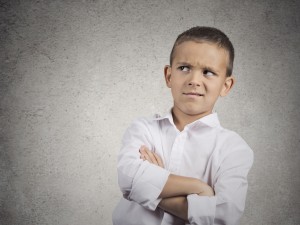 Closeup up portrait headshot suspicious, cautious child boy looking up with disbelief, skepticism isolated grey wall background. Human facial expressions emotions body language perception attitude