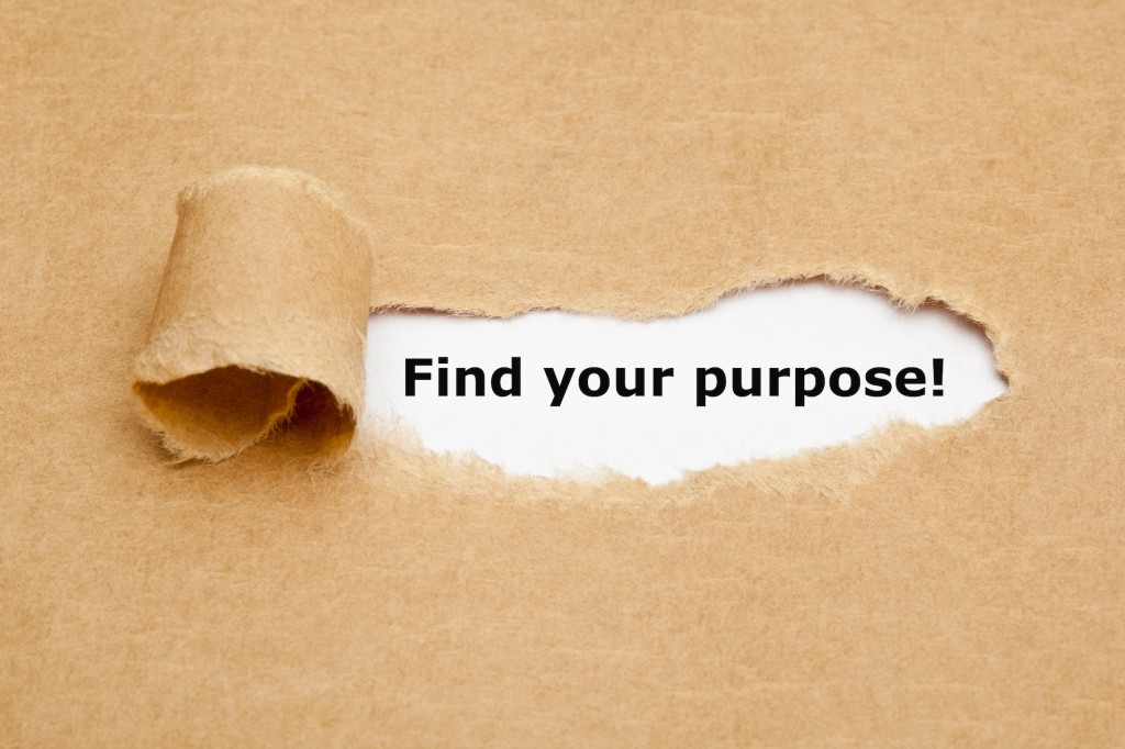 "Find your purpose" appearing behind torn brown paper.
