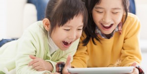happy asian little girls using tablet computer