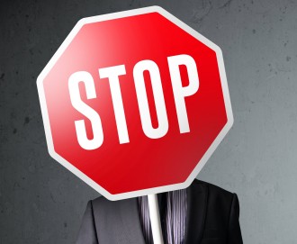 Businessman standing and holding a stop sign in front of his head